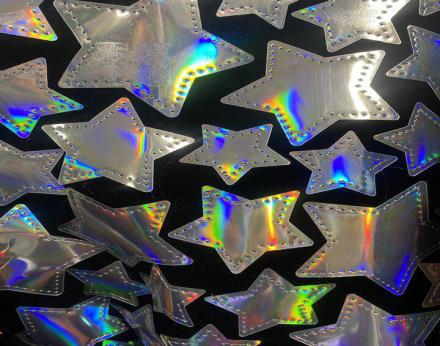 Tejido de terciopelo negro adornado con estrellas platas en tornasol