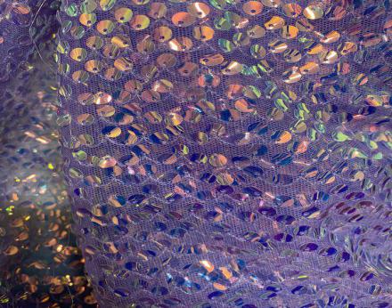 Tejido de tul adornado con lentejuelas holograma cosidas en lila, verde agua y beig.
